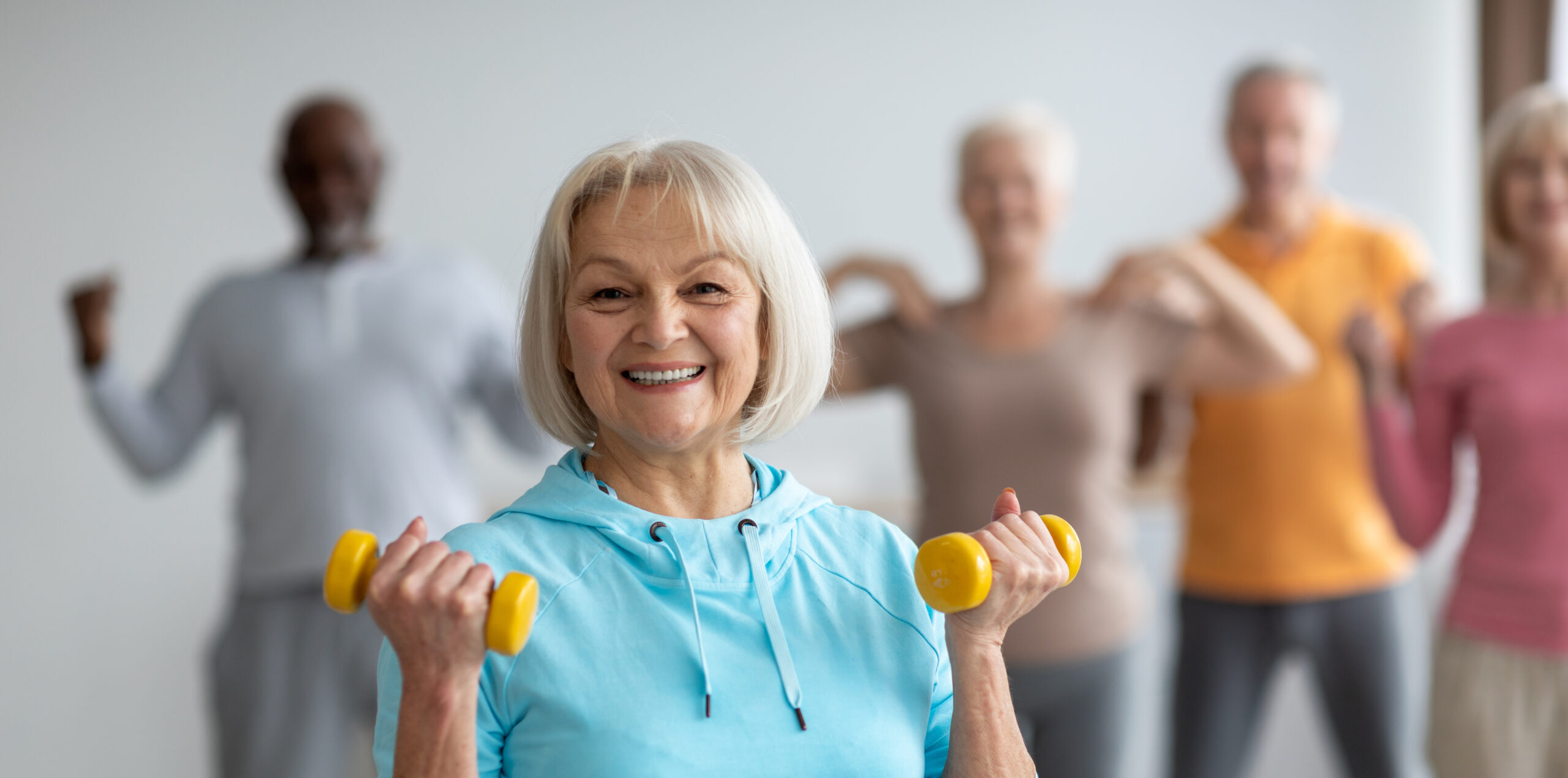 A group of seniors exercising with dumbbells.
